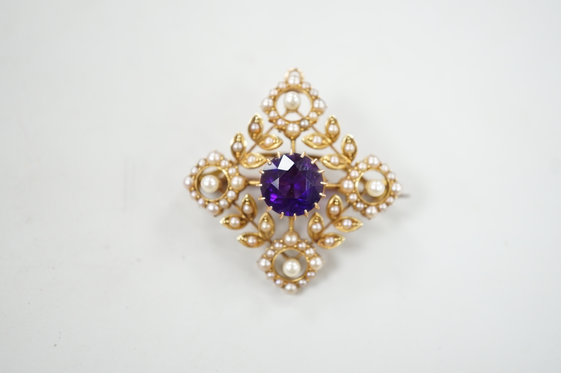 An Edwardian yellow metal, amethyst and seed pearl cluster set pendant brooch, 33mm, gross weight 7.4 grams.